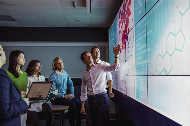 people in a datacentre discussing the security with laptop