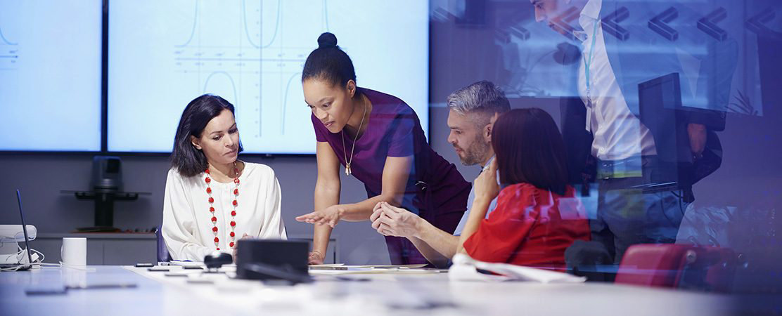 Colleagues talking at a desk