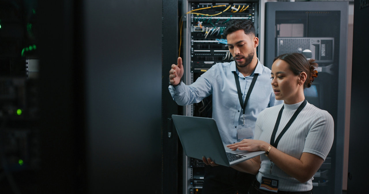 people in a datacentre discussing the security with laptop