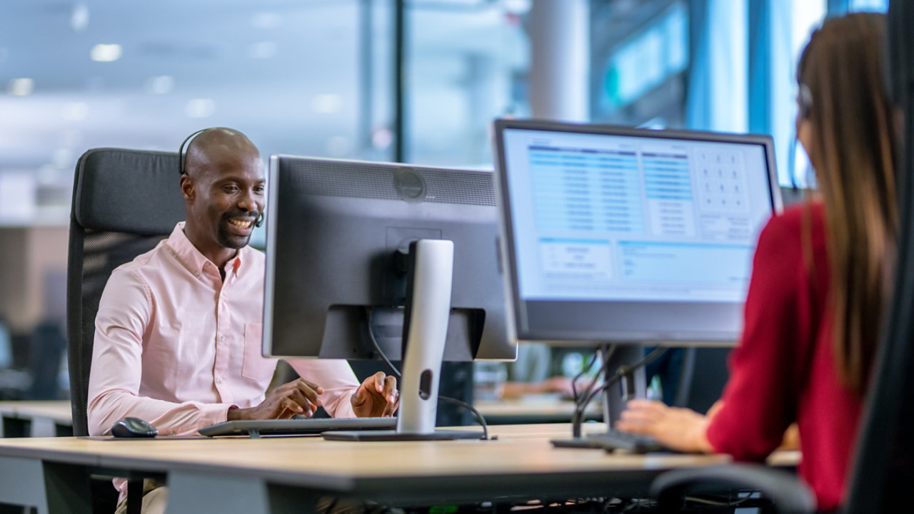 support workers with headsets at office computers