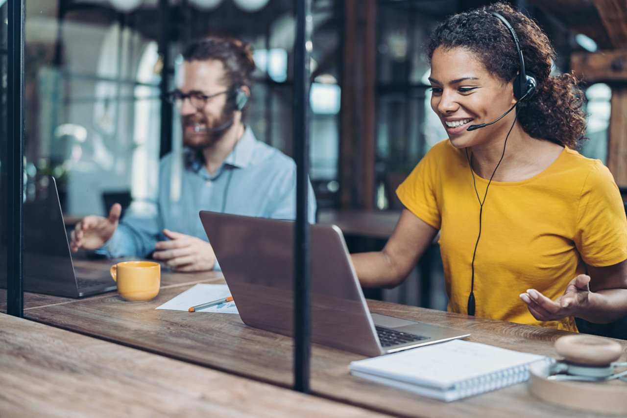customer support workers on laptops with headsets