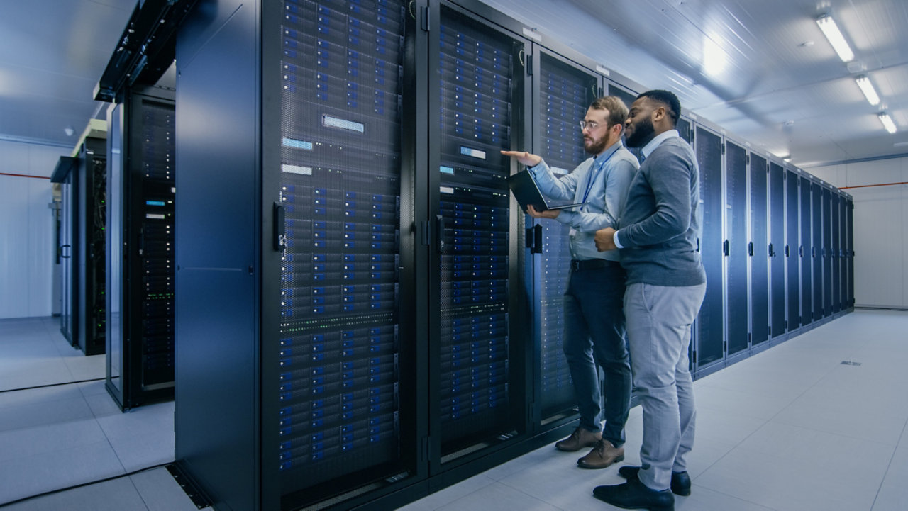 people in a data centre with a laptop