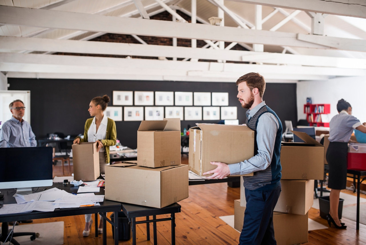 Business people moving boxes at work