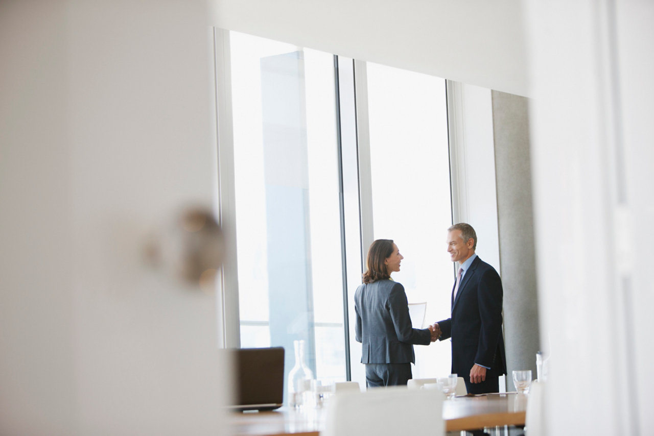 Business people shaking hands in conference room