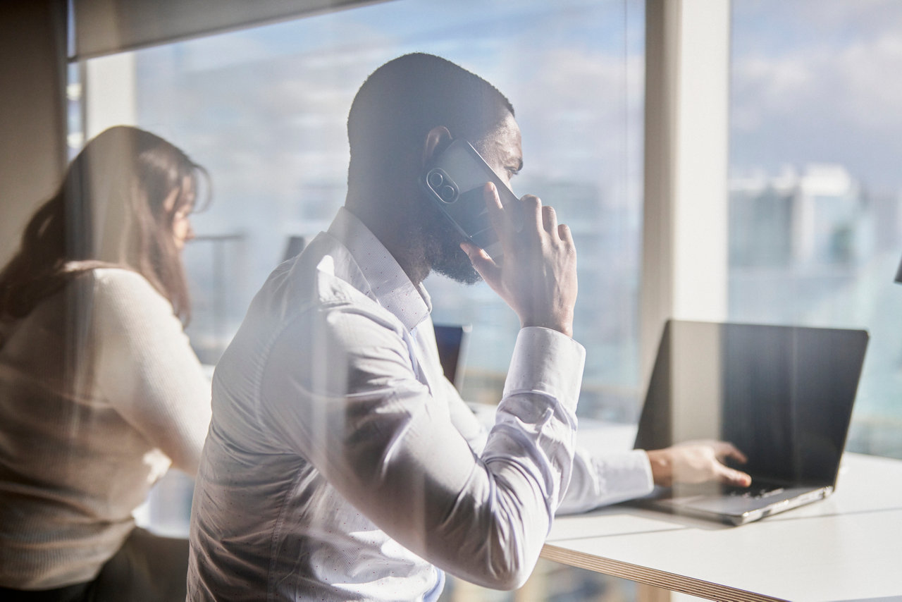 people on the phone in a sunny office with city view
