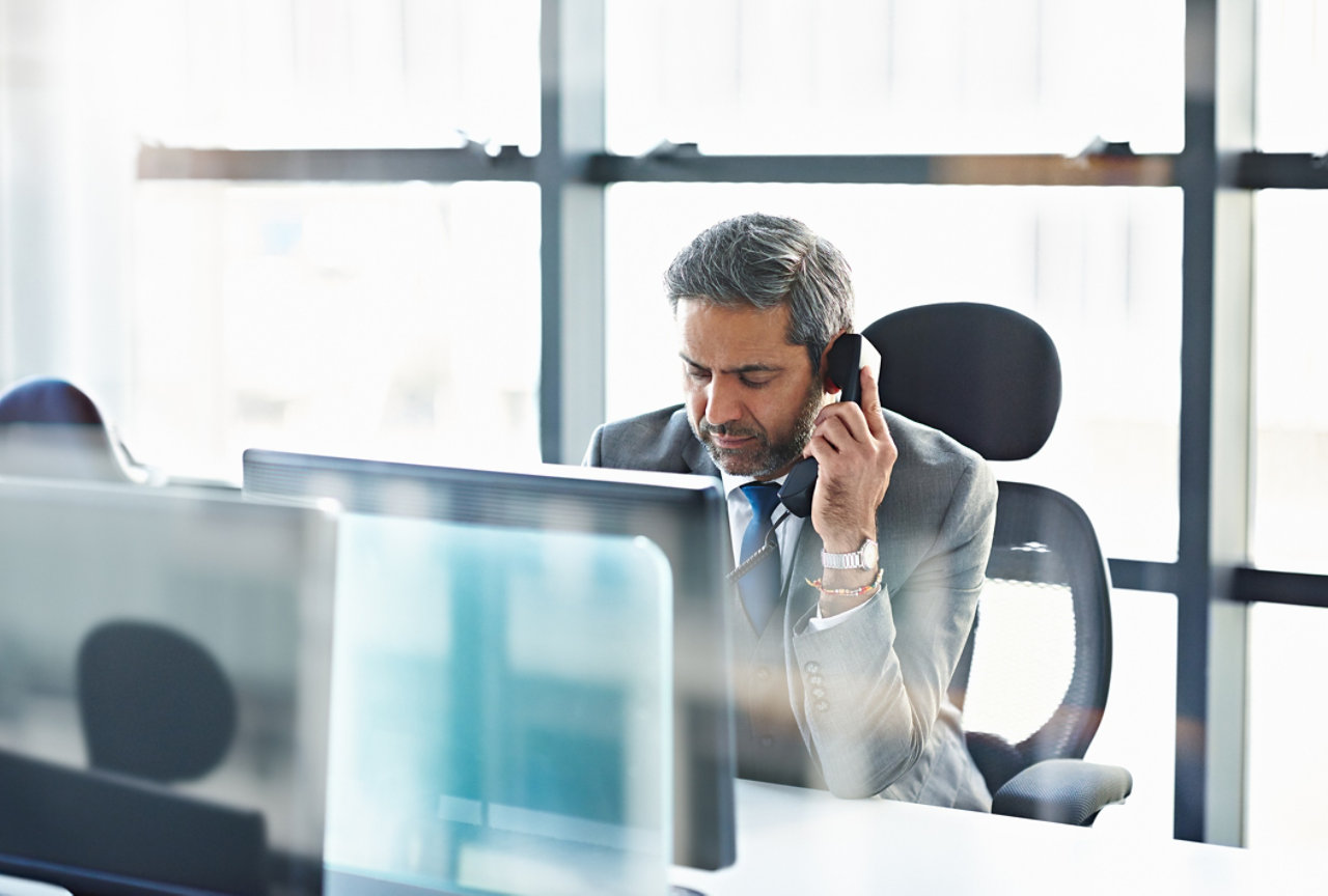 Business man at desk using phone