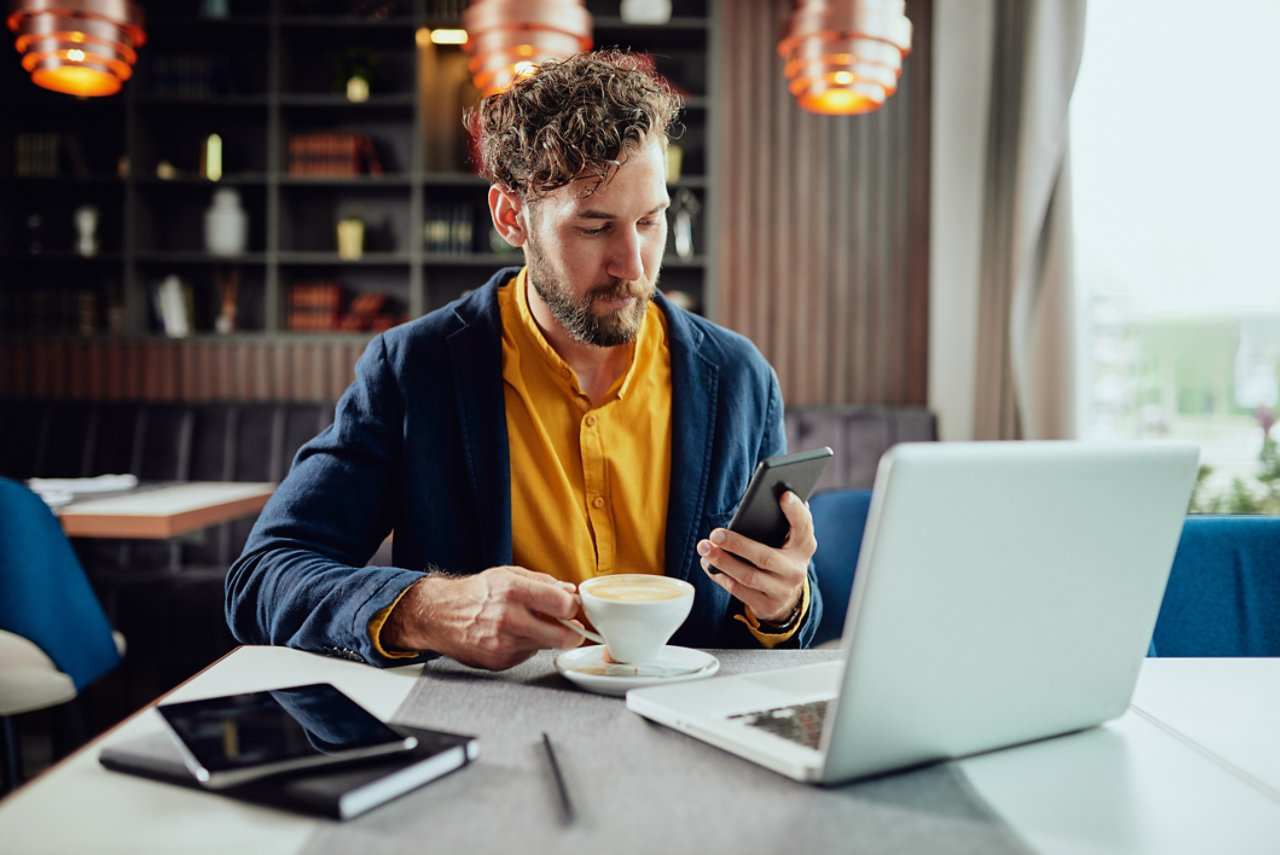 businessman using smart phone and drinking coffee