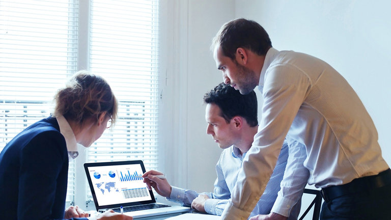 Business people looking at a laptop