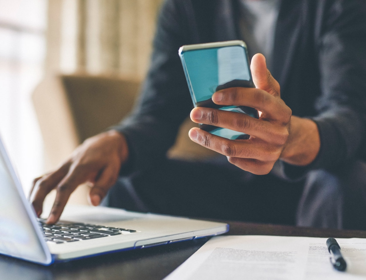 Man using smartphone and laptop