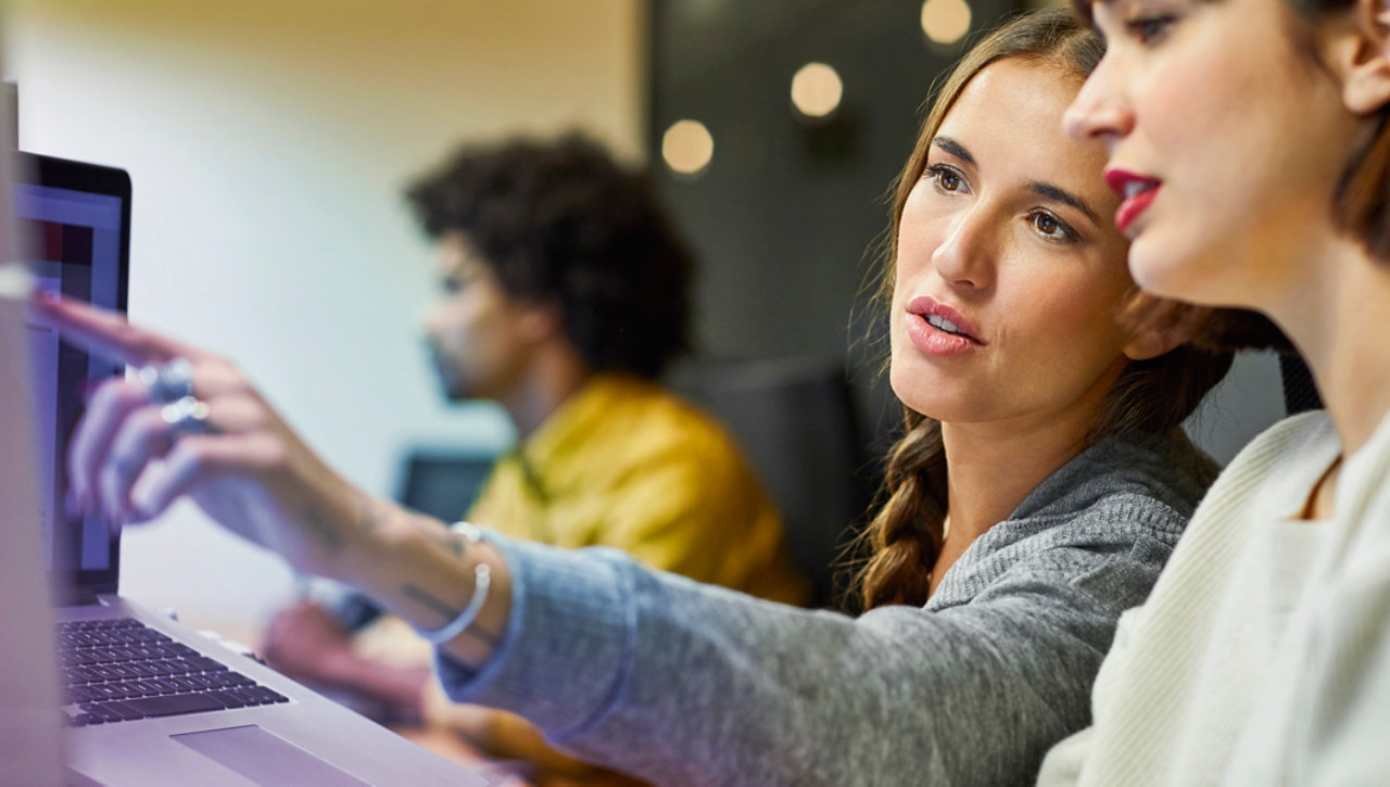 coworkers discussing over computer in office