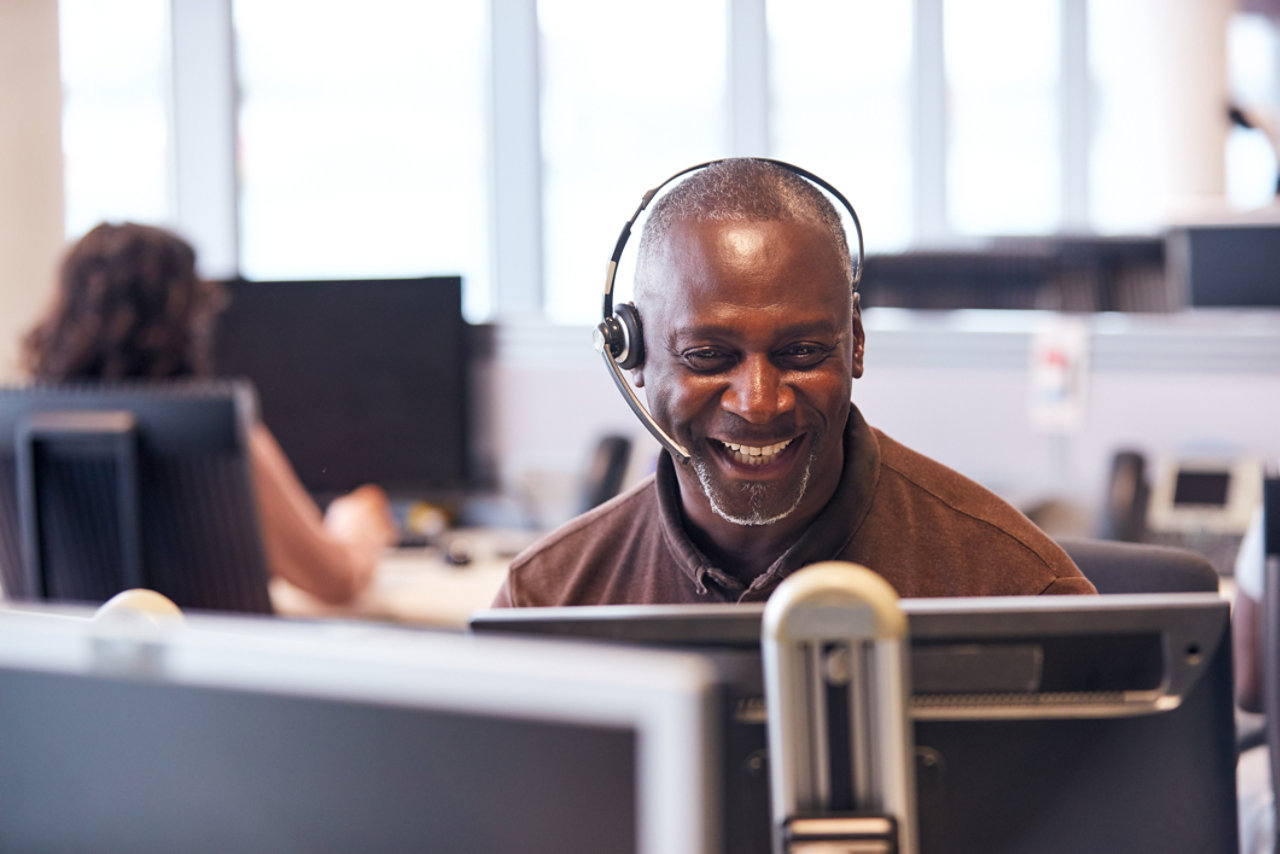 man smiling as he works in an office