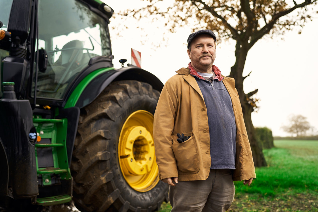 farmer stood by tractor