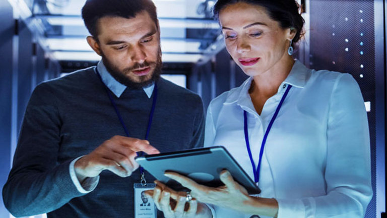 Woman using ipad in server room