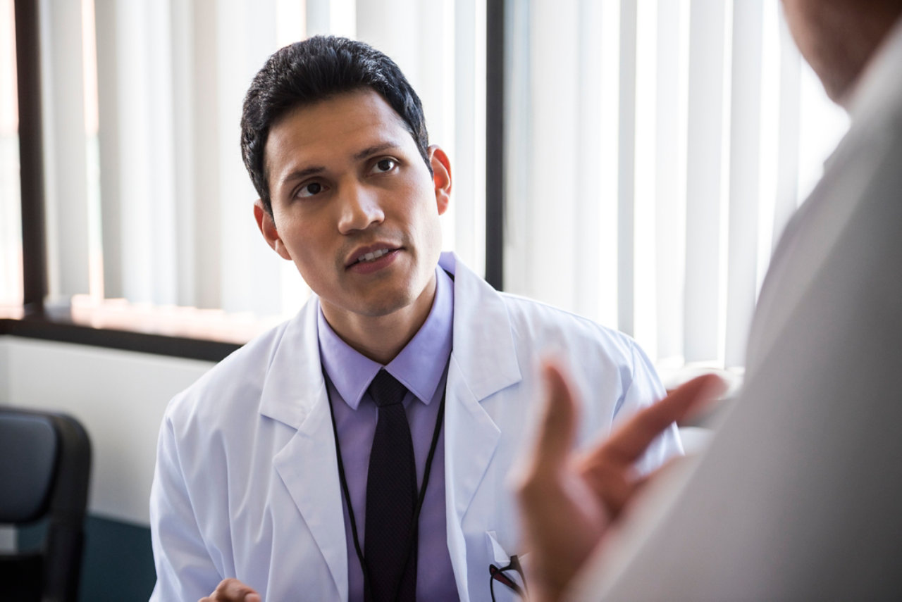 Doctor listening to patient in hospital