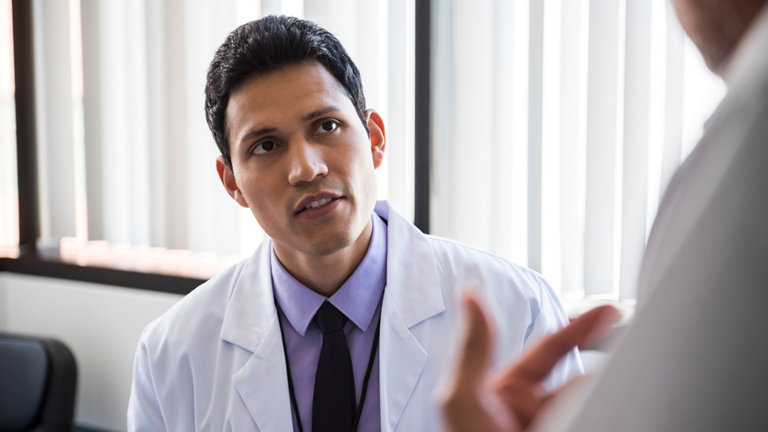 Doctor listening to patient in hospital