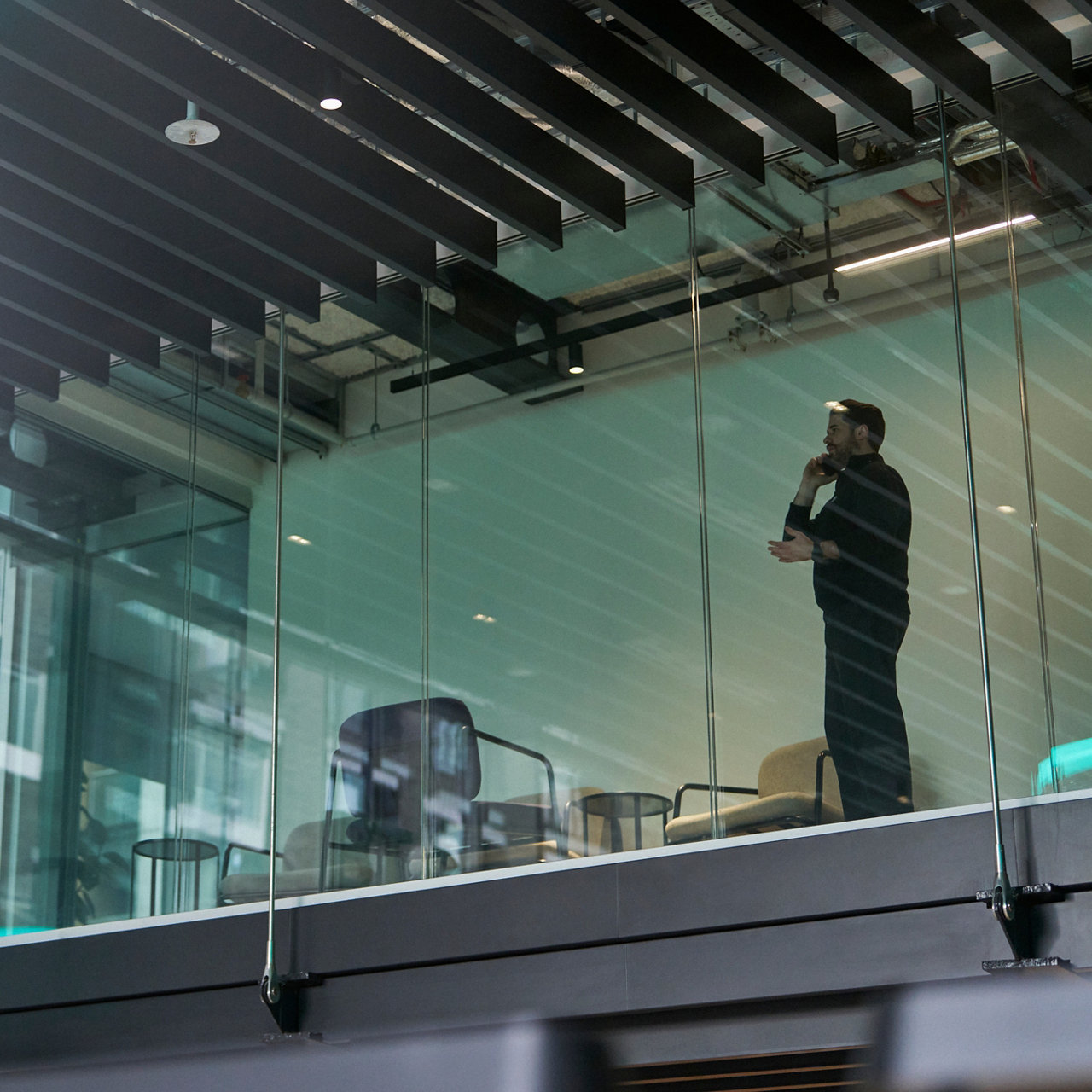 view of person in a glass office building talking on a device