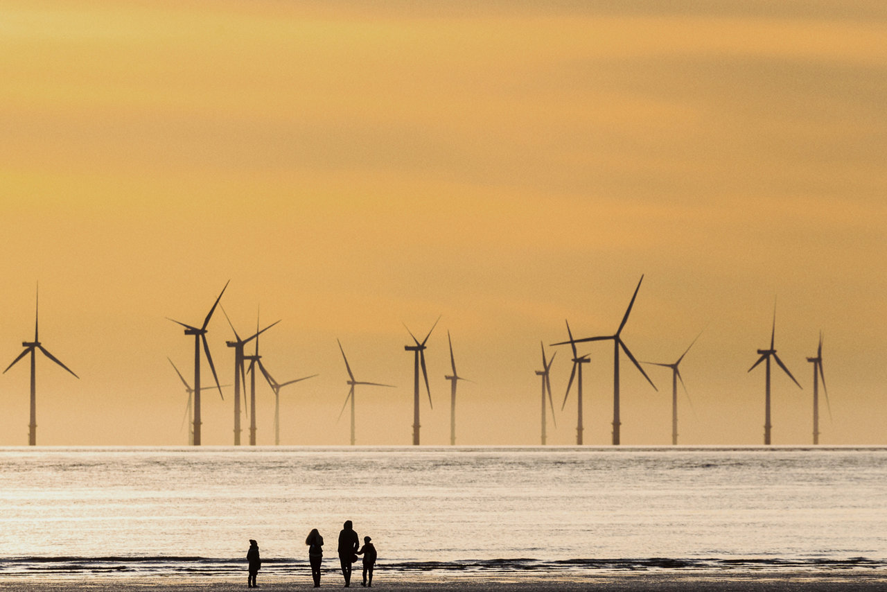 windmill farm in the sea with sunset