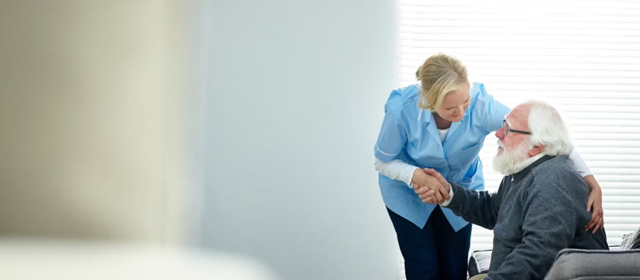 Female caregiver supporting elderly male patient