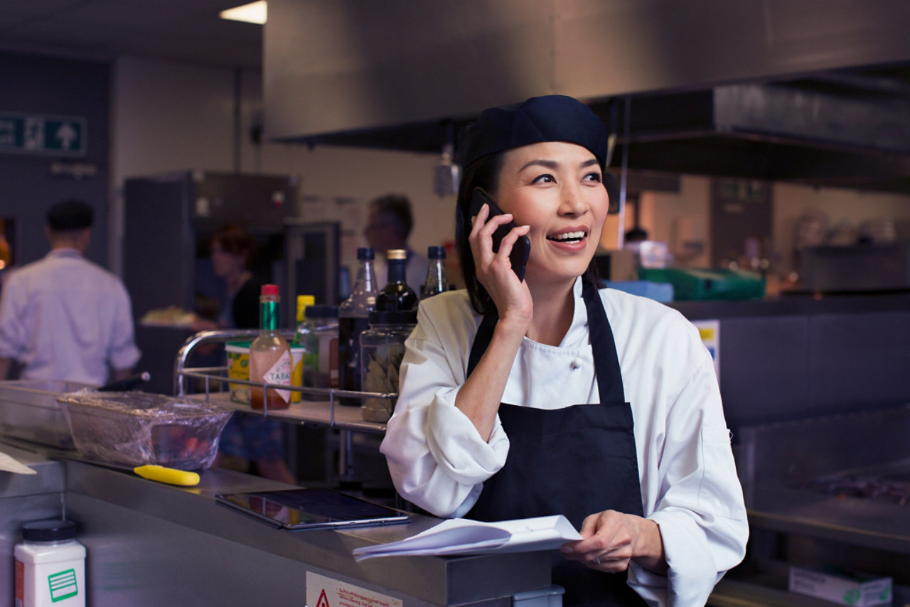 female chef using her mobile in a commercial kitchen