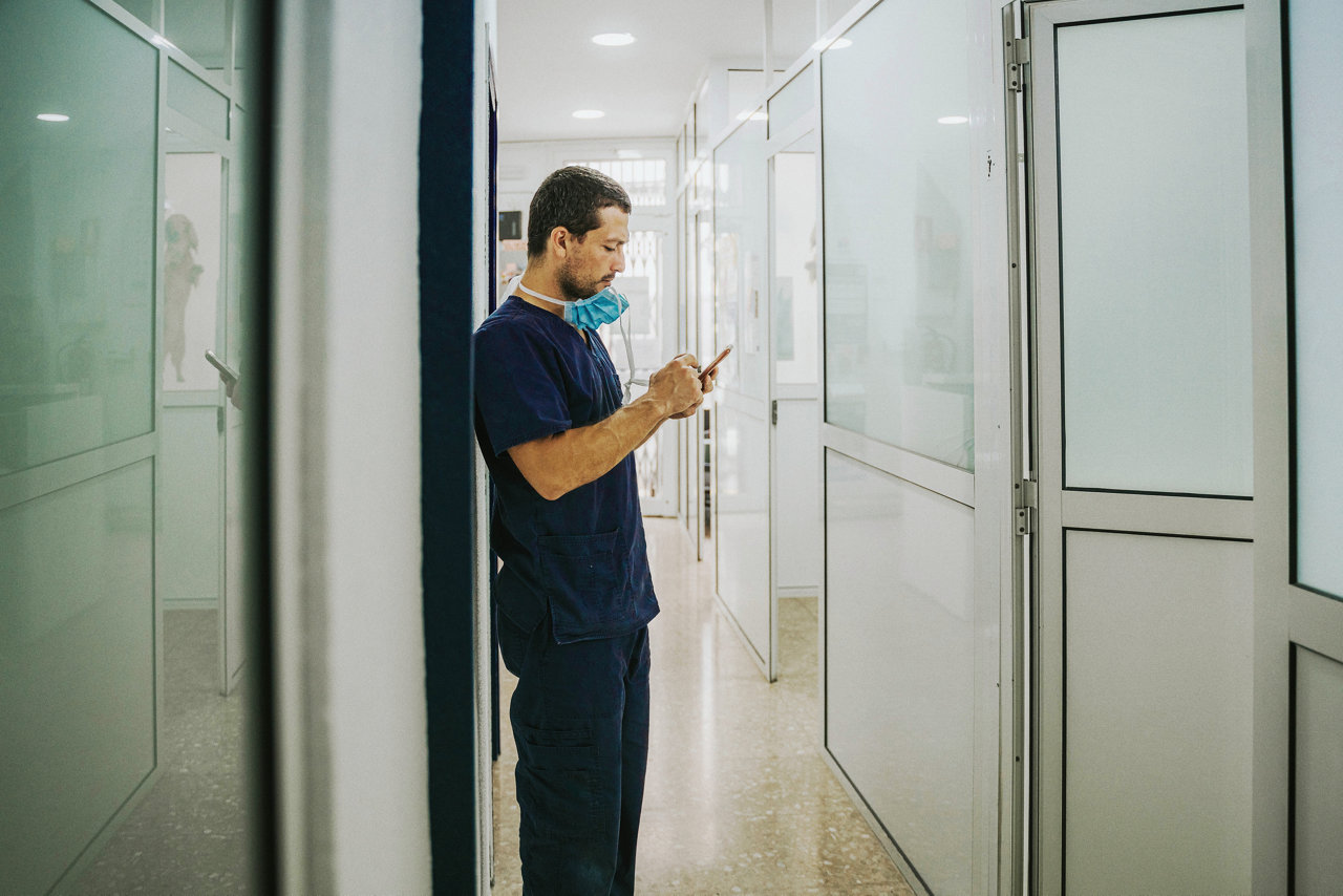 healthcare worker in scrubs uses mobile