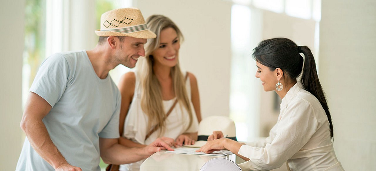 A couple talking to a hotel receptionist