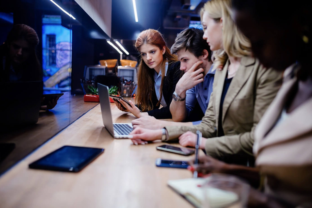 people in a datacentre discussing the security with laptop