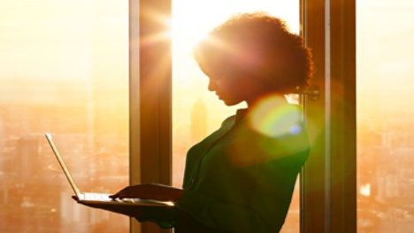 lady holding laptop near window