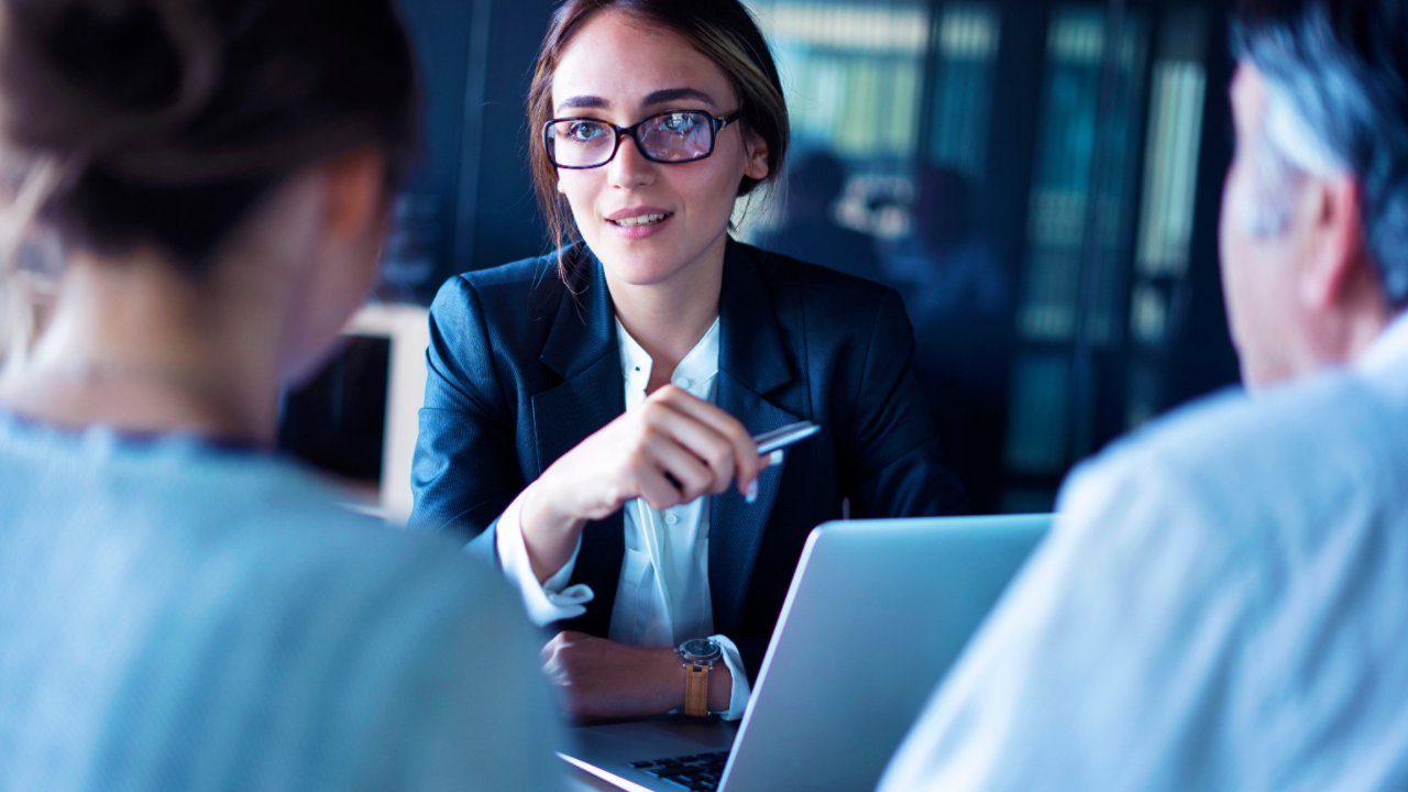 lady at desk in a meeting holding phone