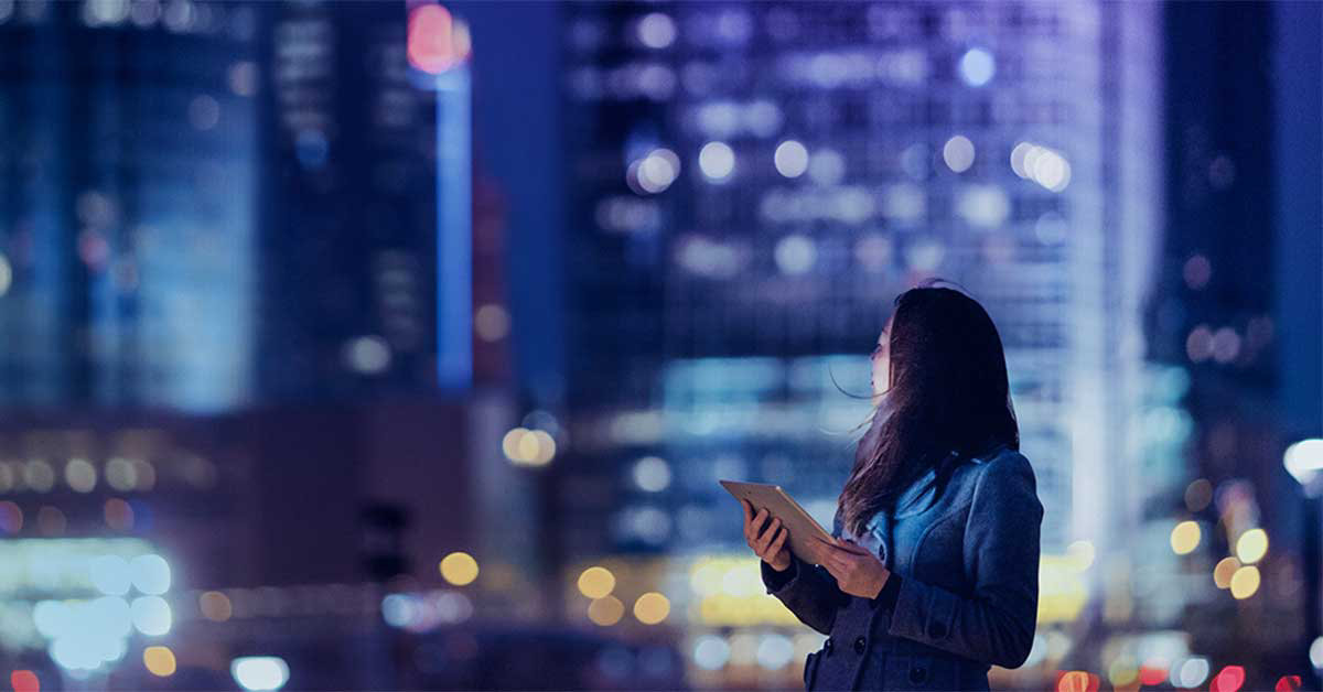 lady outside in city holding tablet