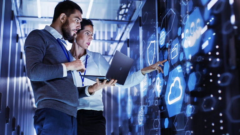 man and woman co-workers standing and pointing in digital room