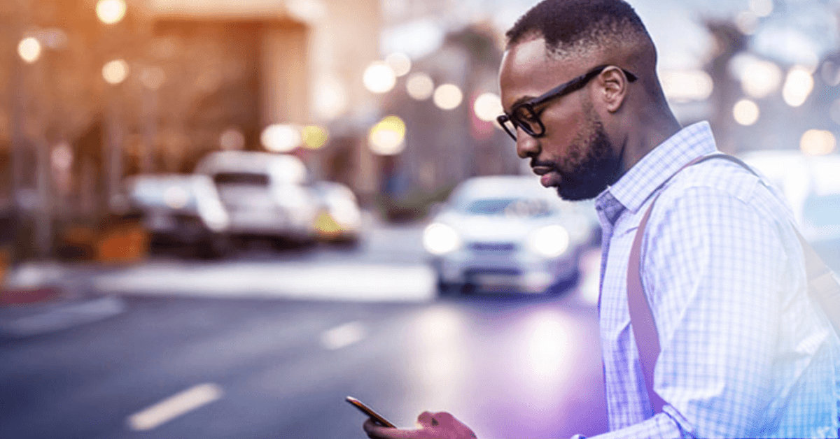 man near road looking at phone