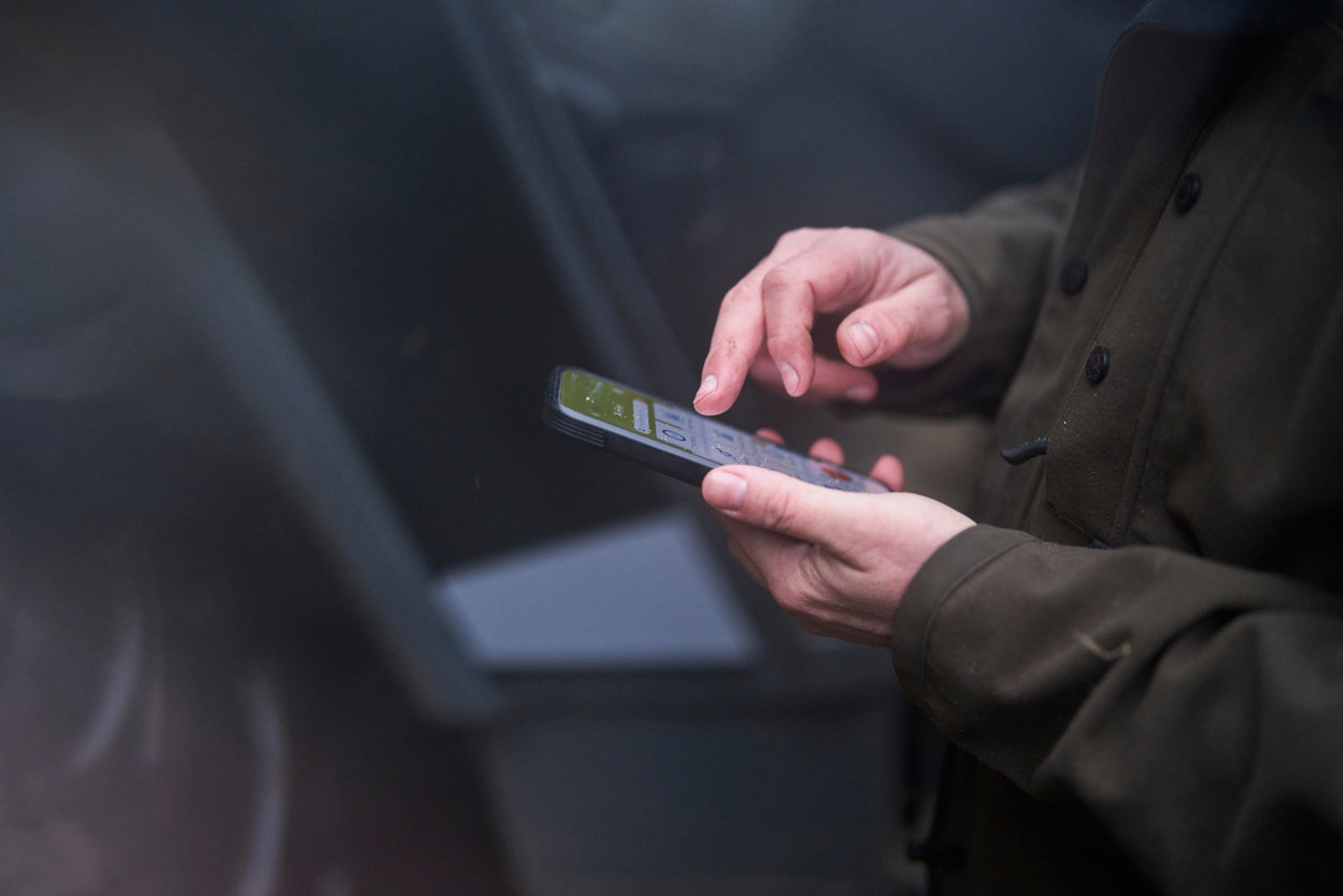 man holding phone on farm
