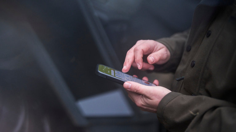 man holding phone on farm