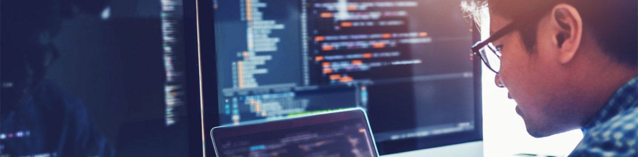 man looking at big computer screen