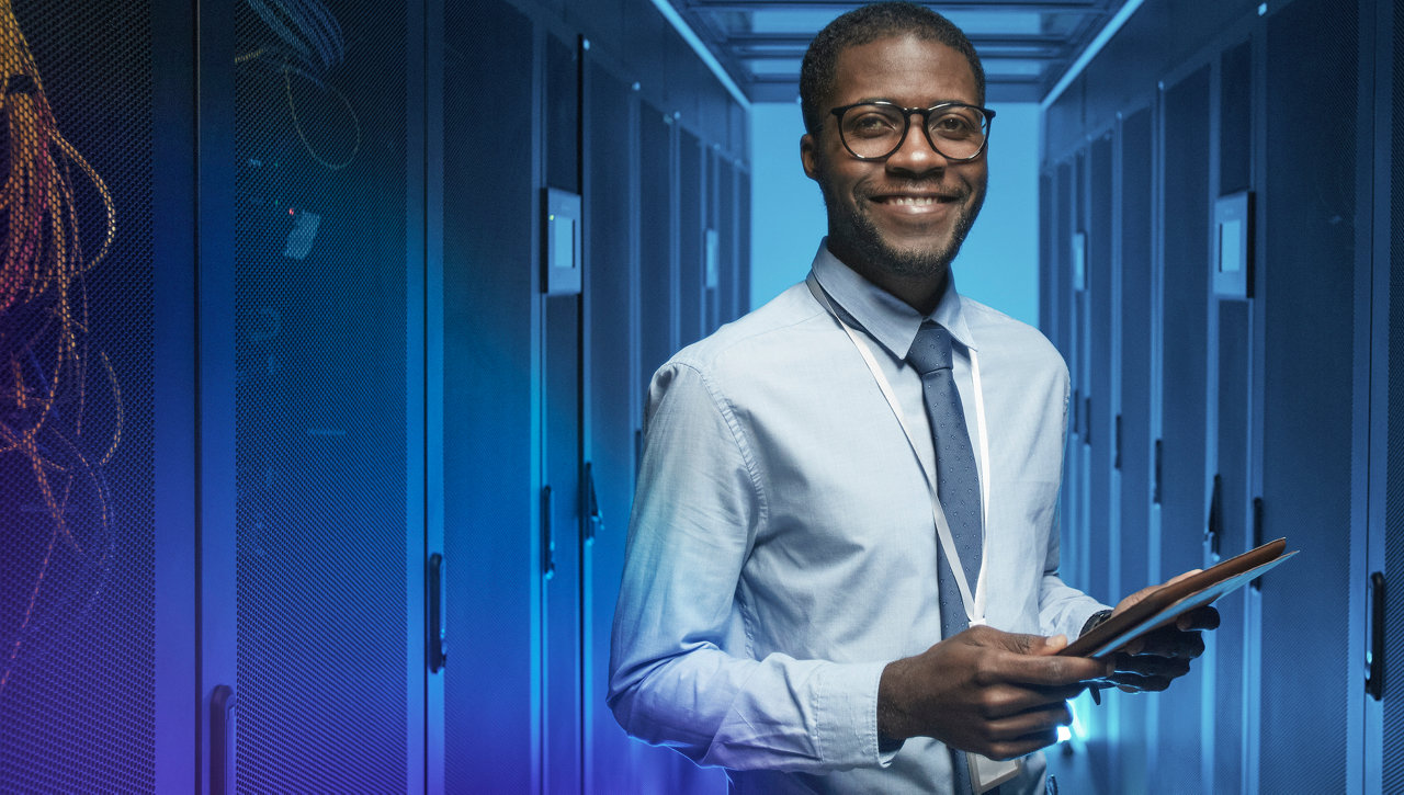 man smiling in front of servers