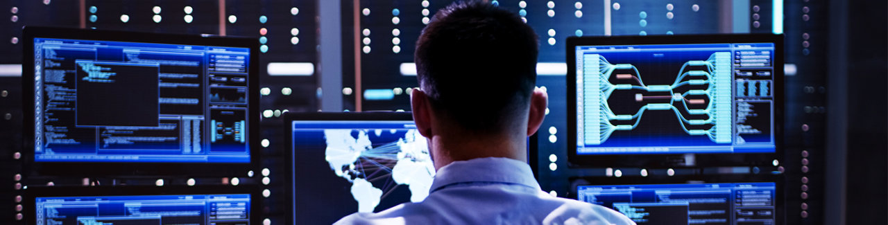 man looking at multiple digital display screens