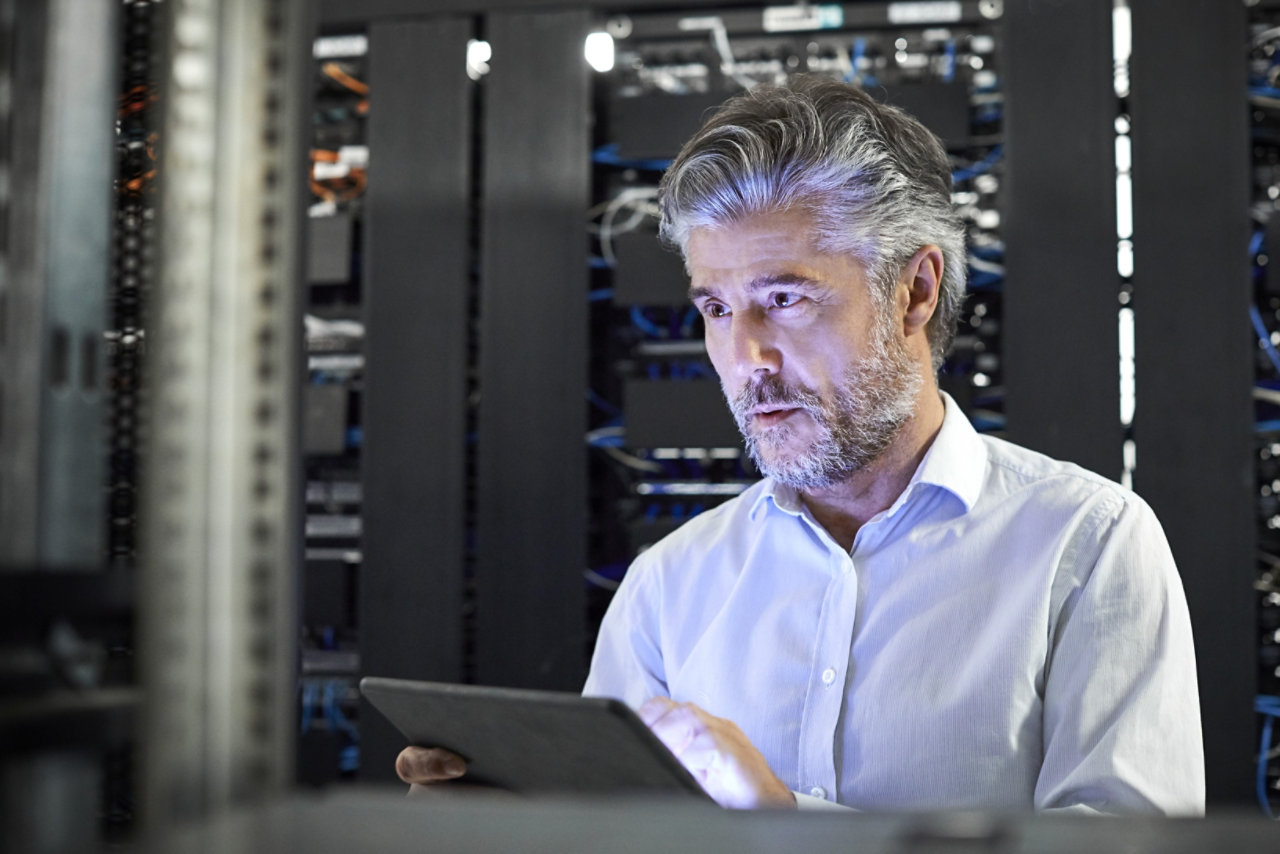 Man with tablet at data centre