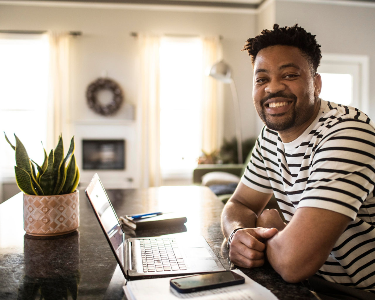 man working from home at desk smiling into camera