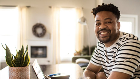 man working from home smiling at desk
