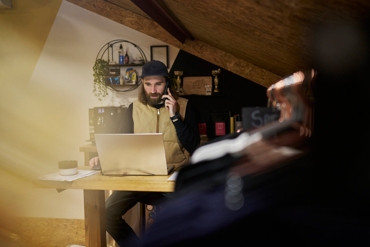 person working on laptop in small shop