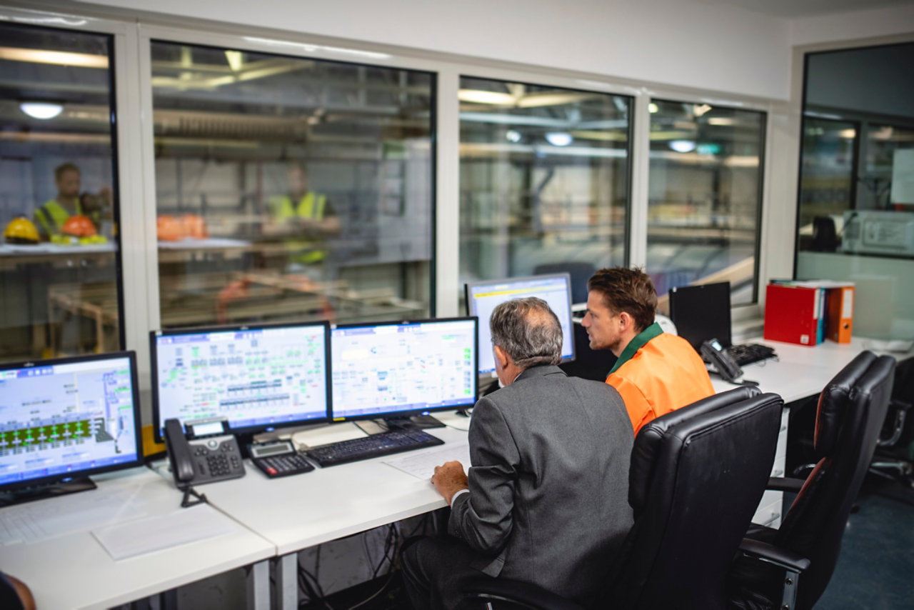 Manager and worker monitoring computers at waste facility