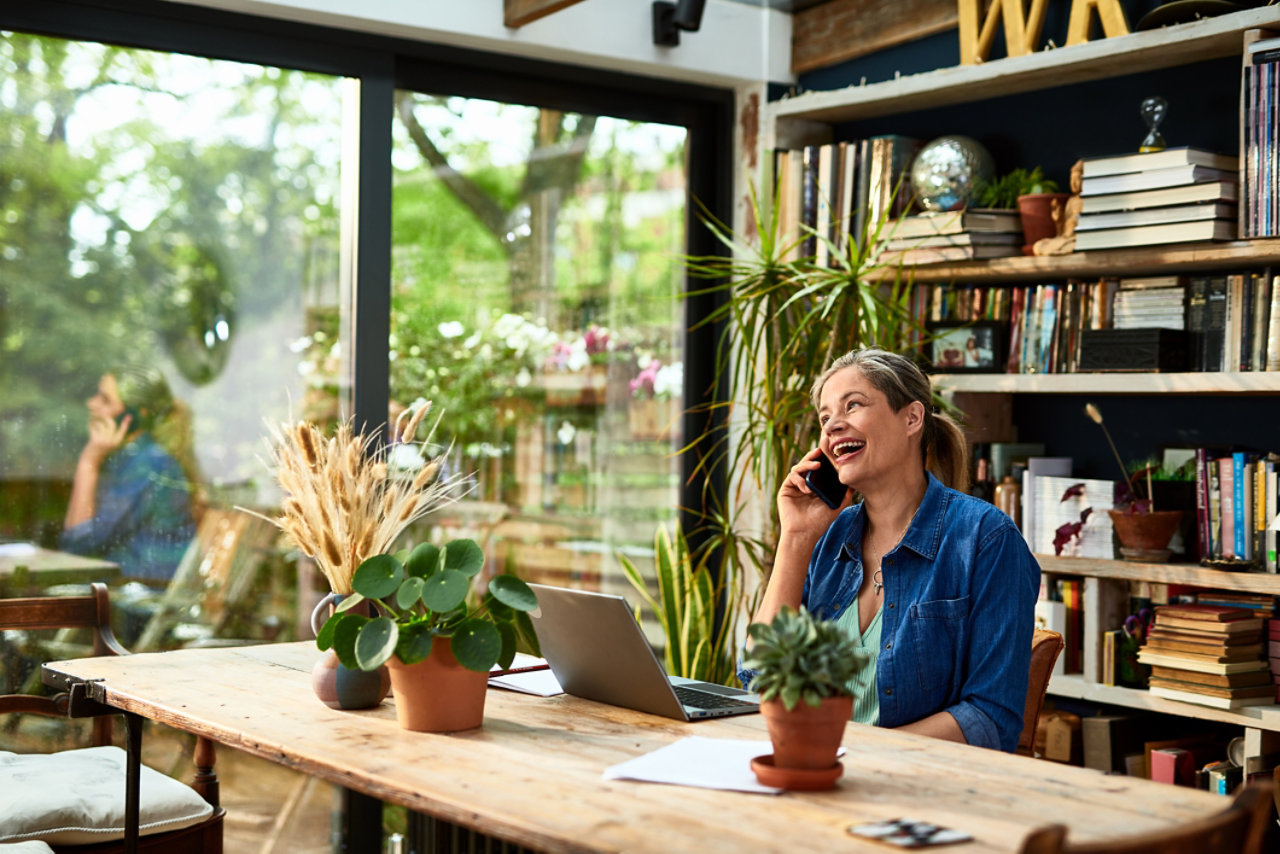 mature woman smiling and laughing on mobile phone