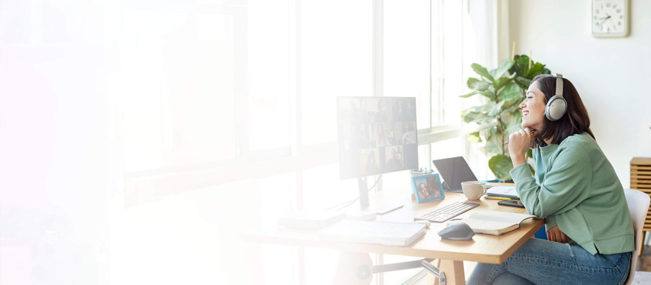 woman wearing a headset at computer on a business call in home office