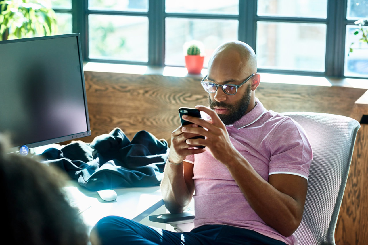 mid adult man with beard and glasses texting