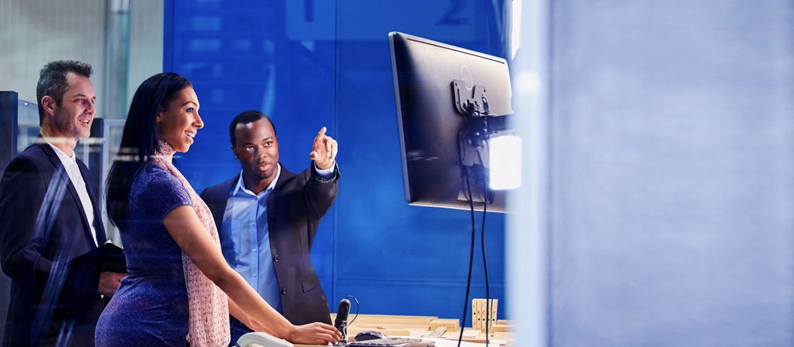 Three people looking at a computer screen