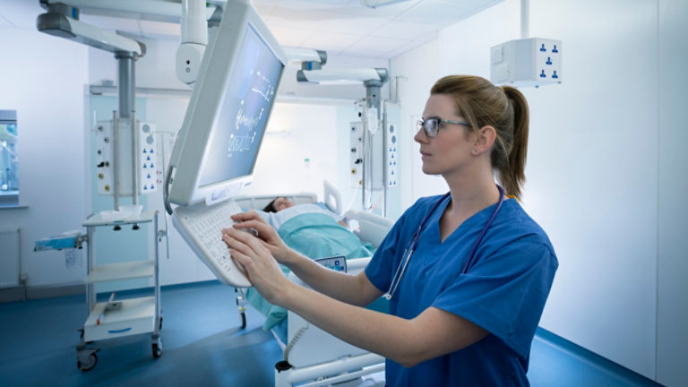Nurse inspecting screen in intensive care unit
