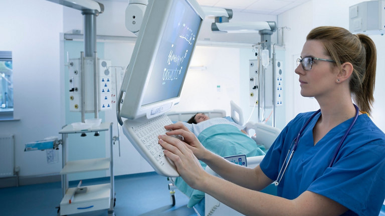 Nurse inspecting screen in intensive care unit in hospital