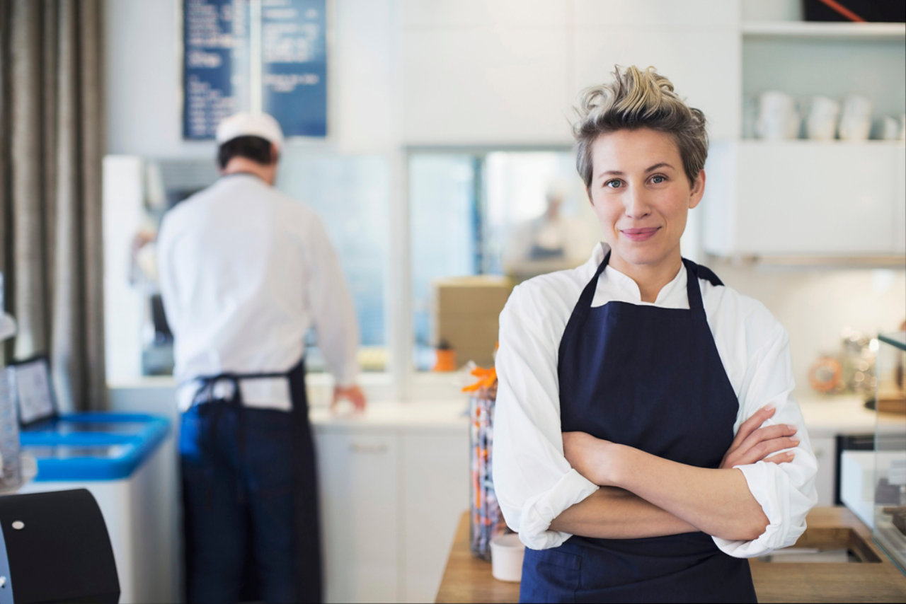 Coffee shop owner standing by the till