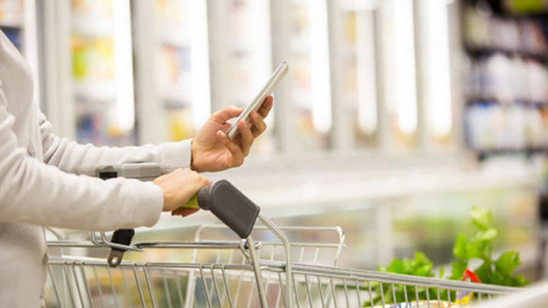 Close up of someone looking at their phone in the supermarket 
