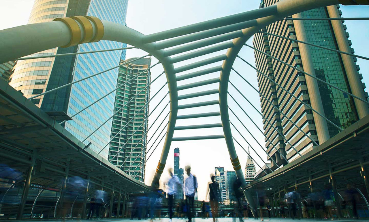 people walking over bridge in the city